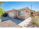 Well-kept home showcasing tidy landscaping, a two-car garage, and a welcoming entrance with decorative rock accents at 2721 N 107Th Dr, Avondale, AZ 85392