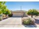 Charming home featuring a well-maintained front yard with a spacious driveway and lush trees at 2721 N 107Th Dr, Avondale, AZ 85392