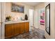 A hallway with a cabinet, mirror, and doors leading to other rooms, including one of the bedrooms at 2721 N 107Th Dr, Avondale, AZ 85392