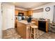 A kitchen features wood cabinetry, modern appliances, and a functional island with countertop at 2721 N 107Th Dr, Avondale, AZ 85392