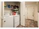 A laundry room has a side-by-side washer and dryer with storage space and tile floors at 2721 N 107Th Dr, Avondale, AZ 85392