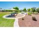 Community playground with a shaded play structure, nearby walking path, and open grassy areas at 2721 N 107Th Dr, Avondale, AZ 85392