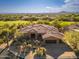 Stunning aerial view of a desert home with tile roof, lush desert landscaping, and a golf course at 28768 N 95Th Way, Scottsdale, AZ 85262