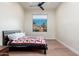 Bedroom with hardwood floors, ceiling fan and large picture window showcasing desert landscape at 28768 N 95Th Way, Scottsdale, AZ 85262