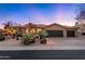 Southwestern home with desert landscaping, a three car garage, and a sunset backdrop at 28768 N 95Th Way, Scottsdale, AZ 85262