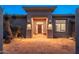 Charming front entrance with beautiful desert landscaping, seating, and warm lighting at 28768 N 95Th Way, Scottsdale, AZ 85262