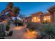 Inviting home exterior featuring desert landscaping, a tiled walkway, and warm lighting at twilight at 28768 N 95Th Way, Scottsdale, AZ 85262