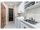 Well-organized laundry room with ample counter space, modern appliances, and custom cabinetry at 28768 N 95Th Way, Scottsdale, AZ 85262