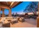 Cozy outdoor living space with comfortable seating, a fireplace, and a stunning twilight view at 28768 N 95Th Way, Scottsdale, AZ 85262