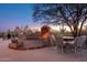 Backyard patio with a cozy outdoor fireplace, seating, and a built-in grill for outdoor cooking and entertaining at 28768 N 95Th Way, Scottsdale, AZ 85262