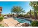 Desert landscaping surrounds a freeform pool and patio with grill and outdoor dining area at 28768 N 95Th Way, Scottsdale, AZ 85262