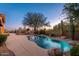 Stunning backyard with a pool, lush desert plants, and outdoor seating, perfect for twilight relaxation at 28768 N 95Th Way, Scottsdale, AZ 85262