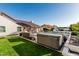 Lush backyard with a modern hot tub, stylish outdoor furniture, and artificial grass at 3054 E Norwood St, Mesa, AZ 85213
