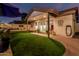 Inviting backyard with covered patio, manicured lawn, and red brick border at 3054 E Norwood St, Mesa, AZ 85213