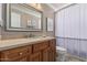Bathroom features wood cabinets, a large mirror, and a shower with a modern shower curtain at 3054 E Norwood St, Mesa, AZ 85213