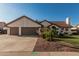 Charming single-story home featuring a terracotta roof, lush landscaping, and a spacious three-car garage at 3054 E Norwood St, Mesa, AZ 85213