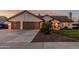Charming single-story home boasts a three-car garage, beautiful landscaping, and desert-toned facade at 3054 E Norwood St, Mesa, AZ 85213