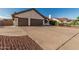 Single-story home with a three-car garage, desert landscaping, and spacious driveway at 3054 E Norwood St, Mesa, AZ 85213