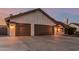 Single-story home with a three-car garage, desert landscaping, and spacious driveway at 3054 E Norwood St, Mesa, AZ 85213