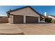 Single-story home with a three-car garage, desert landscaping, and spacious driveway at 3054 E Norwood St, Mesa, AZ 85213