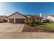 Inviting single-story home with lush green lawn, mature landscaping, and desert-toned facade at 3054 E Norwood St, Mesa, AZ 85213