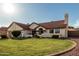 Inviting one-story home with well-manicured lawn, complemented by a beautiful red tile roof and desert landscaping at 3054 E Norwood St, Mesa, AZ 85213