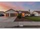 Charming single-story home boasts a three-car garage, beautiful landscaping, and desert-toned facade at 3054 E Norwood St, Mesa, AZ 85213