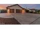 Single-story home with a three-car garage, desert landscaping, and spacious driveway at 3054 E Norwood St, Mesa, AZ 85213