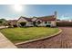 Charming single-story home featuring a lush green lawn, beautiful landscaping, and a classic red tile roof at 3054 E Norwood St, Mesa, AZ 85213