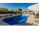 Backyard pool with waterfall feature, complemented by manicured landscaping and a seating area with an umbrella at 3054 E Norwood St, Mesa, AZ 85213
