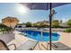 Sparkling pool with sun loungers and umbrella, set against a beautifully landscaped backyard at 3054 E Norwood St, Mesa, AZ 85213