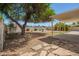 Backyard with covered patio, desert landscape, mature trees, and privacy fence at 3118 W Aster Dr, Phoenix, AZ 85029