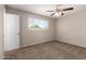 Cozy bedroom features neutral walls, carpet flooring, ceiling fan, and a view of greenery at 3118 W Aster Dr, Phoenix, AZ 85029