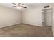 Well-lit living room with neutral walls, carpet flooring, ceiling fan and a seamless doorway to the next room at 3118 W Aster Dr, Phoenix, AZ 85029