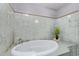 Relaxing bathroom featuring a large oval soaking tub with decorative tile accents at 3539 W Davidson Ln, Phoenix, AZ 85051