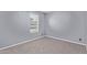 A clean bedroom featuring plush neutral carpeting and a window for natural light at 3539 W Davidson Ln, Phoenix, AZ 85051
