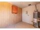 Functional utility room featuring storage, water heater, and wood paneled walls at 3539 W Davidson Ln, Phoenix, AZ 85051