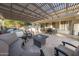 Expansive backyard patio with a built-in kitchen, grill, lounge chairs, dining table, and a central fire pit at 4636 E Carriage Ct, Gilbert, AZ 85297