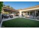 Beautiful backyard with a hot tub, artificial turf, and a covered patio with comfortable seating for outdoor relaxation at 4636 E Carriage Ct, Gilbert, AZ 85297