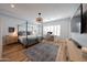 Spacious main bedroom with four-poster bed, wood floors, and bright natural light at 4636 E Carriage Ct, Gilbert, AZ 85297