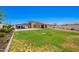 Expansive backyard featuring a manicured lawn and covered outdoor kitchen at 4654 W Suncup Dr, San Tan Valley, AZ 85144