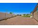 Expansive backyard with rock landscaping, enclosed by a concrete fence, featuring a trampoline and playground at 4654 W Suncup Dr, San Tan Valley, AZ 85144