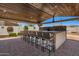 A covered outdoor bar with brick accents, bar seating and open air at 4654 W Suncup Dr, San Tan Valley, AZ 85144