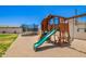 Backyard features a wood playground and a black framed trampoline on a sand and grass lot at 4654 W Suncup Dr, San Tan Valley, AZ 85144