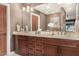 Bathroom features double sinks with a marble countertop and custom wood cabinets for ample storage at 4909 N Woodmere Fairway -- # 1004, Scottsdale, AZ 85251