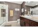 Bathroom with neutral tiling, glass shower and vanity with marble countertop and dark wood cabinets at 4909 N Woodmere Fairway -- # 1004, Scottsdale, AZ 85251