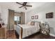 Cozy bedroom with a decorative quilt, wood floors, ceiling fan and large windows with outdoor view at 4909 N Woodmere Fairway -- # 1004, Scottsdale, AZ 85251