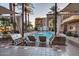 Upscale outdoor grilling area with lounge chairs and a swimming pool in a luxury complex at 4909 N Woodmere Fairway -- # 1004, Scottsdale, AZ 85251