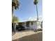 Well-maintained mobile home with carport, landscaped yard, and car in driveway at 530 S Alma School Rd # 75, Mesa, AZ 85210