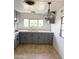 Spacious kitchen has painted cabinets, a double basin sink, laminate countertops, and vintage chandelier at 530 S Alma School Rd # 75, Mesa, AZ 85210